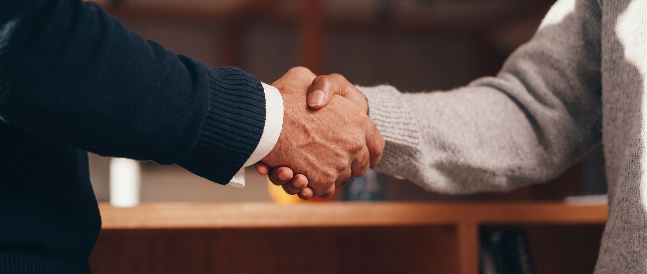 Aperto de mãos entre advogado e cliente ao fim de uma reunião